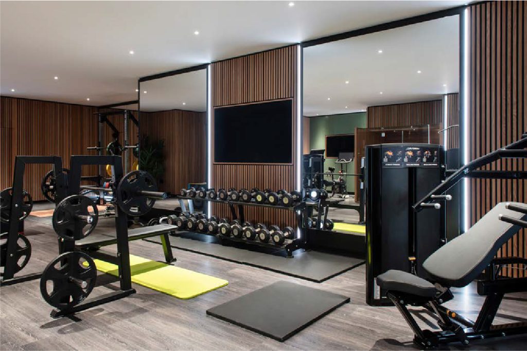 Bespoke home gyms installation &ndash; premium dumbbell rack and adjustable bench in a luxury fitness space by OOSH Ltd